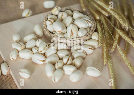 Il salato Pistacchi Noci rustico sul blocco di legno Foto Stock