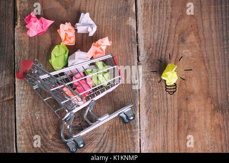 Carrello spesa e piccole sfere di carta. Pensando di nuova idea. Idee sull'e-commerce, e-commerce o e-commerce Foto Stock