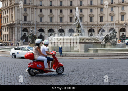 Coppia giovane su una Vespa scooter a Piazza della Repubblica a Roma, Italia Foto Stock