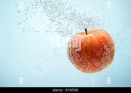Dolce di mele rosse galleggianti in acqua shot Foto Stock