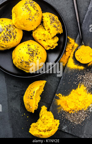 Pane panini hamburger con superfoods curcuma e chia sull'ardesia blackbackground. Vista superiore Foto Stock