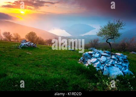 Il lago d'Iseo, al tramonto. L'isola di Monte Isola nel mezzo del lago, chiuso nelle montagne che dividono le due province di Bergamo e Brescia Foto Stock