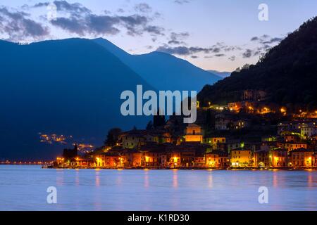 Peschiera Maraglio poco dopo il tramonto, le luci del piccolo villaggio di Montisola, l'isola lacustre più grande d'Europa, in provincia di Brescia Foto Stock