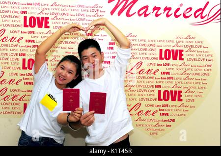 Wuxi, cinese della provincia di Jiangsu. 28 Agosto, 2017. Una giovane coppia posano per le foto con i loro certificati di matrimonio al matrimonio registration office a Wuxi, Cina orientale della provincia di Jiangsu, Agosto 28, 2017. Molte coppie hanno scelto di sposarsi di lunedì, che è il tradizionale Festival Qixi o cinese il giorno di San Valentino. Credito: Huan Yueliang/Xinhua/Alamy Live News Foto Stock