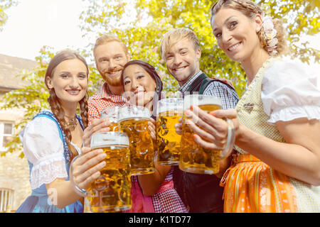 Amici nel giardino della birra con bicchieri da birra Foto Stock