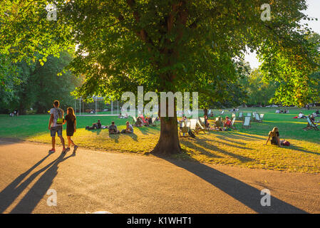 London Park coppia estiva, vista su una serata estiva di persone che si rilassano e socializzano a St James's Park, centro di Londra, Inghilterra Regno Unito. Foto Stock