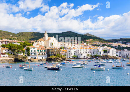 Dipinto di bianco città di Cadaqués, sormontato dalla chiesa di Santa Maria si affaccia su barche in acque blu della baia di Cadaqués, Catalogna, Spagna Foto Stock