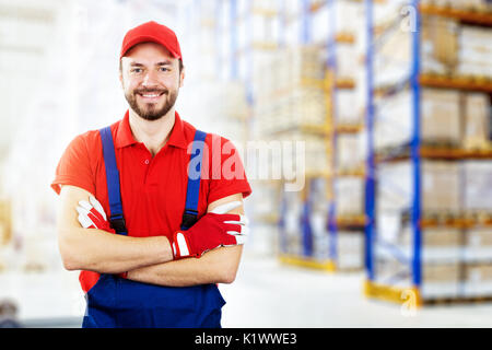 Sorridente giovane operaio di magazzino in rosso uniforme. spazio copia Foto Stock