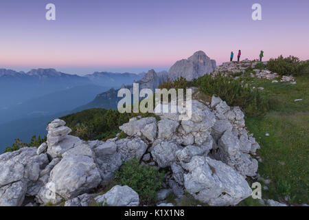 L'Europa, Italia, Veneto. Gli escursionisti sulla prima pala di San Lucano summit guardando il sorgere del sole. Dolomiti Agordine, Belluno, Italia Foto Stock