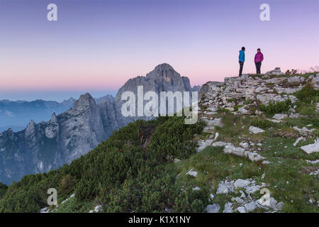 L'Europa, Italia, Veneto. Gli escursionisti sulla prima pala di San Lucano summit guardando il sorgere del sole. Dolomiti Agordine, Belluno, Italia Foto Stock