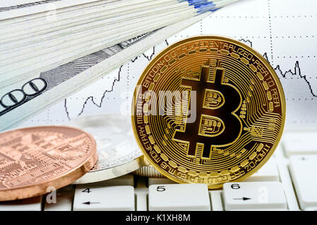 Golden Bitcoin moneta sulla tastiera del laptop. mercato azionario grafico. Concetto di trading Foto Stock
