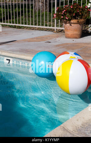 Beachball colorato galleggiante in una bella piscina comunale nel sud della California Stati Uniti Foto Stock