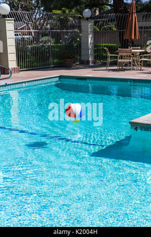 Beachball colorato galleggiante in una bella piscina comunale nel sud della California Stati Uniti Foto Stock