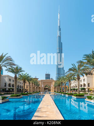 Palace hotel di città, palme e fontane, sul retro il Burj Khalifa, Dubai, emirato Dubai Emirati Arabi Uniti Foto Stock