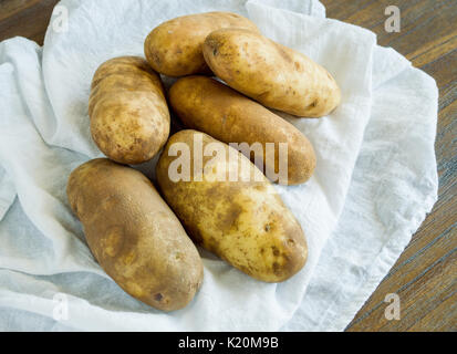 Still Life 6 patate impilati su un panno bianco visto dal di sopra Foto Stock
