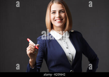 Imprenditrice a scrivere qualcosa con un pennarello rosso Foto Stock