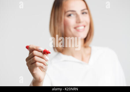 Imprenditrice a scrivere qualcosa con un pennarello rosso Foto Stock