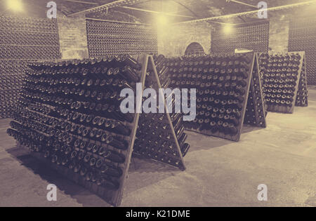 Vino spumante bottiglie in vetro fermentare in cantina Foto Stock