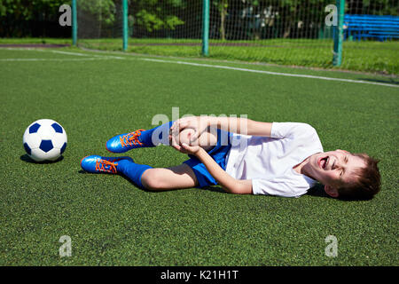 Lesioni del ginocchio nel calcio Ragazzo giocatore di calcio Foto Stock