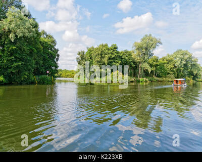 Un piccolo cabinato sul fiume Bure, vicino a Wroxham,passa l'ingresso al ponte di ampio. Foto Stock