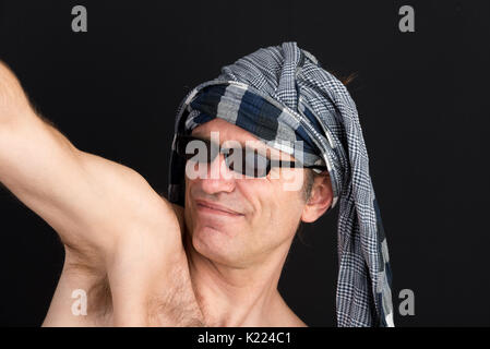 Ritratto di uno strano uomo europeo, utilizzando uno scialle per coprire l'hea Foto Stock