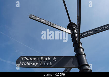 Cartello in East Molesey Surrey, Inghilterra, dando indicazioni per il Thames Path, molesey lock e la stazione ferroviaria Foto Stock