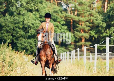 Ragazza adolescente in abbigliamento formale a cavallo nella natura. Foto Stock