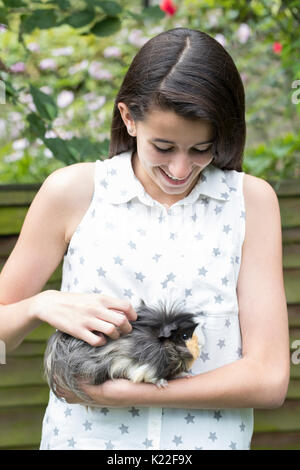 Ragazza nel giardino alla ricerca dopo il Pet cavia Foto Stock