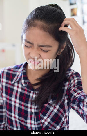 Ragazza giovane prurito cuoio capelluto in camera da letto Foto Stock