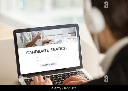 Datore di lavoro con computer portatile alla ricerca di candidati, trovare riprende online Foto Stock