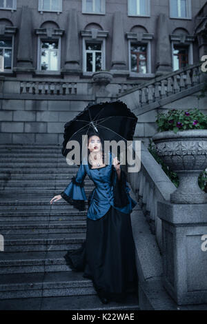 Una donna in costume medievale scuro, una maschera di carnevale femminile e  un grande cappello chic con piume al carnevale di Venezia Foto stock - Alamy