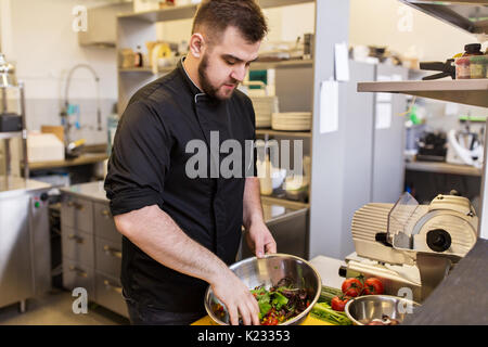 Chef di cucina rendendo il cibo al ristorante cucina Foto Stock