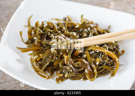 Insalata di alghe marine con semi di sesamo e l'olio. Amore per un sano cibo vegan concetto. Foto Stock