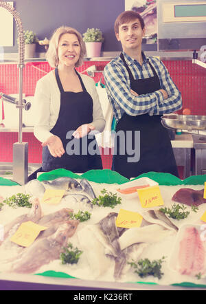 Sorridente negozio europeo roba vendere raffreddata su ghiaccio pesce nel supermercato Foto Stock