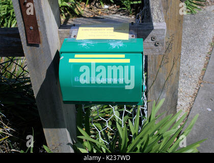 Colore verde sacchetto di plastica dispenser per persona cani a piedi in un parco in Australia Foto Stock