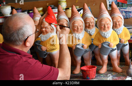 Graefenroda, Germania. 25 Ago, 2017. CEO Reinhard Griebel vernici gnomi presso il garden gnome manufactory in Graefenroda, Germania, 25 agosto 2017. Più di 500 diverse figure tra quattro e 60 centimetri sono fabbricati qui. Dal 1874, la famiglia Griebel ha iniziato la produzione del Burnt argilla figure ed è ora la sola società in Germania. La maggior parte dei clienti al di fuori della Germania sono da Francia, Austria, Italia, Paesi Bassi e Svizzera. Foto: Jens Kalaene/dpa-Zentralbild/dpa/Alamy Live News Foto Stock