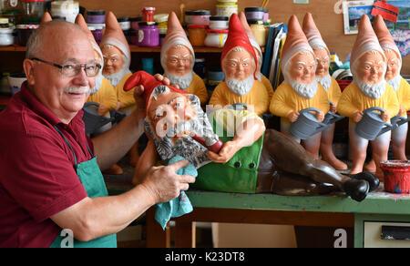 Graefenroda, Germania. 25 Ago, 2017. CEO Reinhard Griebel vernici gnomi presso il garden gnome manufactory in Graefenroda, Germania, 25 agosto 2017. Più di 500 diverse figure tra quattro e 60 centimetri sono fabbricati qui. Dal 1874, la famiglia Griebel ha iniziato la produzione del Burnt argilla figure ed è ora la sola società in Germania. La maggior parte dei clienti al di fuori della Germania sono da Francia, Austria, Italia, Paesi Bassi e Svizzera. Foto: Jens Kalaene/dpa-Zentralbild/dpa/Alamy Live News Foto Stock