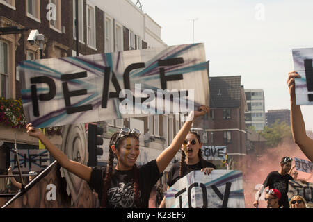 Londra, Regno Unito. 28 Agosto, 2017. Il 28 agosto 2017. Gente che si diverte nel carnevale di Notting Hill con Grenfell torre in background. Credito: Sebastian Remme/Alamy Live News Foto Stock