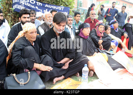 Srinagar, Indiano Kashmir amministrato:30.Agosto .Presidente del Jammu e Kashmir Liberation Front (JKLF) Yasin Malik, centro, insieme con i parenti del Kashmir mancanti giovani partecipare, in una silenziosa protesta organizzata dall Associazione dei Genitori di Persone scomparse (APDP) per celebrare la Giornata Internazionale degli scomparsi i.APDP esige la costituzione di una commissione di sondare le sparizioni di persone in Kashmir. Secondo l'APDP, alcuni 8.000 a 10.000 persone sono scomparse dall'inizio del conflitto del Kashmir nel 1989. Credito: Sofi Suhail/Alamy Live News Foto Stock