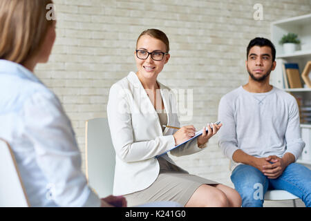 Bellissima femmina psicologo Gruppo leader di sessione di terapia Foto Stock