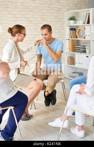 Psichiatra consolante di piangere Giovane Uomo Foto Stock