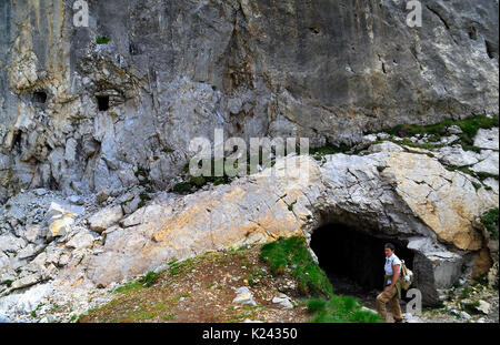 La prima guerra mondiale italiano davanti, le Alpi Carniche, il monte Peralba. Una donna escursionista di fronte all'entrata di una caverna rifugio italiano. sulla sinistra due mitragliatrice nidi. Foto Stock