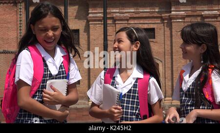 Gli studenti di ridere indossando le uniformi scolastiche Foto Stock