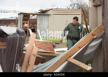 U.S Pattuglia di Confine agent Mario Fuentes ricerche di sopravvissuti tra le macerie di una casa mobile causati dall'uragano Harvey Agosto 27, 2016 in Rockport, Texas. Tiny Rockport fu quasi completamente distrutta dall'uragano Harvey come è venuto a terra come una categoria 4 tempesta con 130mph venti. Foto Stock