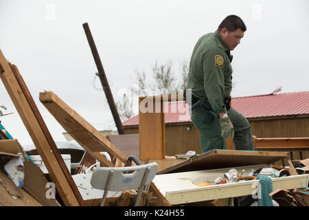 U.S Pattuglia di Confine agent Mario Fuentes ricerche di sopravvissuti tra le macerie di una casa mobile causati dall'uragano Harvey Agosto 27, 2016 in Rockport, Texas. Tiny Rockport fu quasi completamente distrutta dall'uragano Harvey come è venuto a terra come una categoria 4 tempesta con 130mph venti. Foto Stock