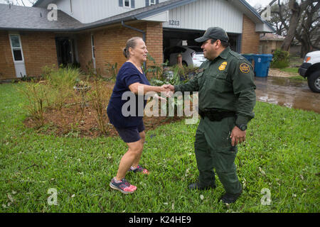 Resident Laurie Kent, destra, grazie U.S confine agenti Patrol dopo aver smontato gli alberi caduti e cancellati i detriti dalla sua casa dopo il passaggio dell uragano Harvey Agosto 28, 2016 in Rockport, Texas. Tiny Rockport fu quasi completamente distrutta dall'uragano Harvey come è venuto a terra come una categoria 4 tempesta con 130mph venti. Foto Stock