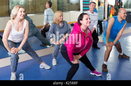 Gruppo di felice adulti facendo esercizio di aerobica in sport club Foto Stock