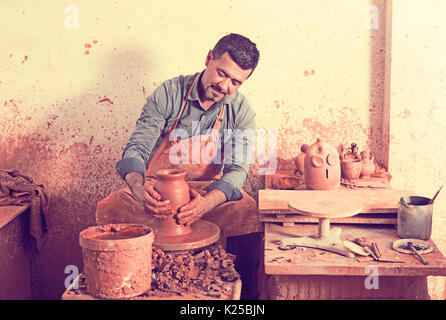 Felice uomo anziano rendendo pot con ruota di ceramiche in studio Foto Stock