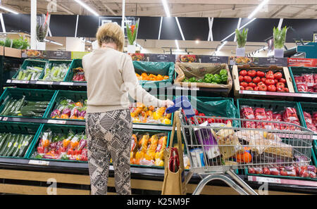 Supermercato Tesco, Regno Unito. Donna matura con carrello in corsia Fruit & Veg. Costo della vita crisi, inflazione, aumento dei prezzi dei prodotti alimentari... Foto Stock