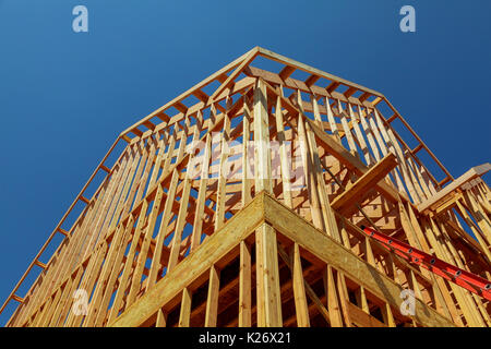 Nuove costruzioni residenziali home framing contro un cielo azzurro e sole nuova casa in costruzione Foto Stock